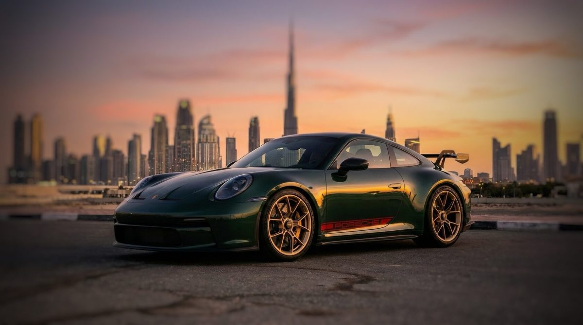 Porsche 911 against the Dubai skyline at sunset